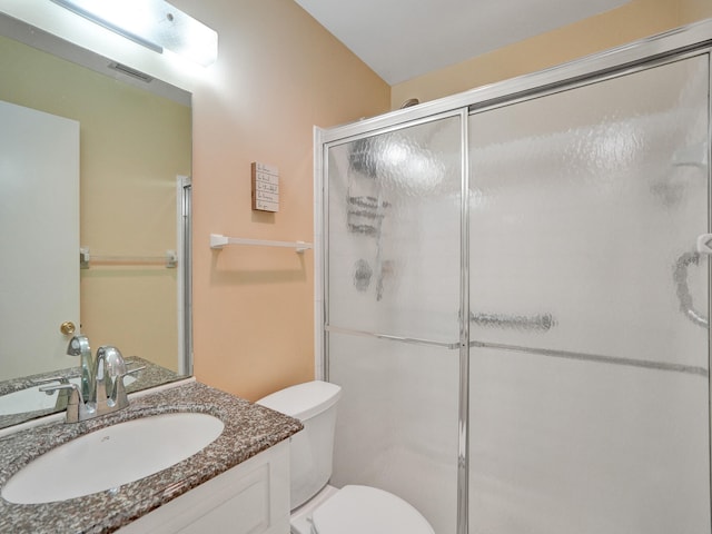 bathroom with vanity, toilet, and a shower with shower door