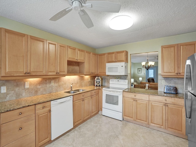 kitchen with decorative backsplash, a textured ceiling, white appliances, ceiling fan with notable chandelier, and sink