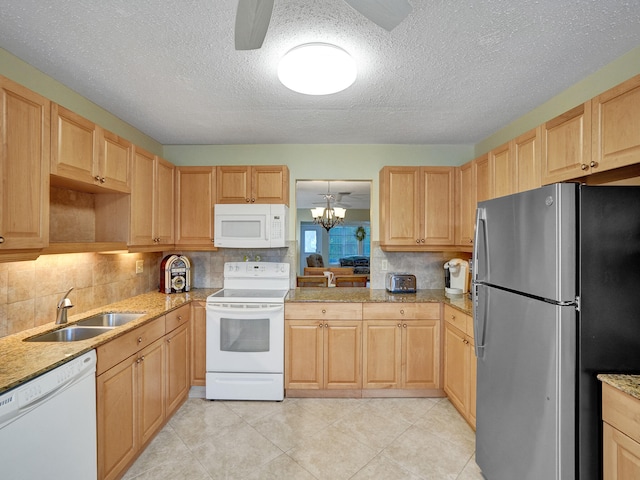 kitchen featuring tasteful backsplash, ceiling fan with notable chandelier, a textured ceiling, white appliances, and sink