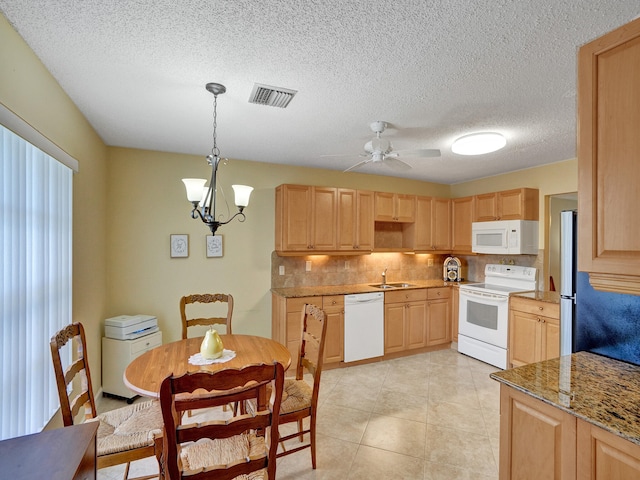 kitchen with pendant lighting, light brown cabinets, and white appliances