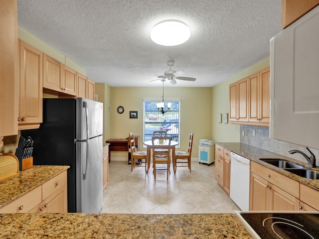 kitchen with light brown cabinetry, decorative light fixtures, and white appliances