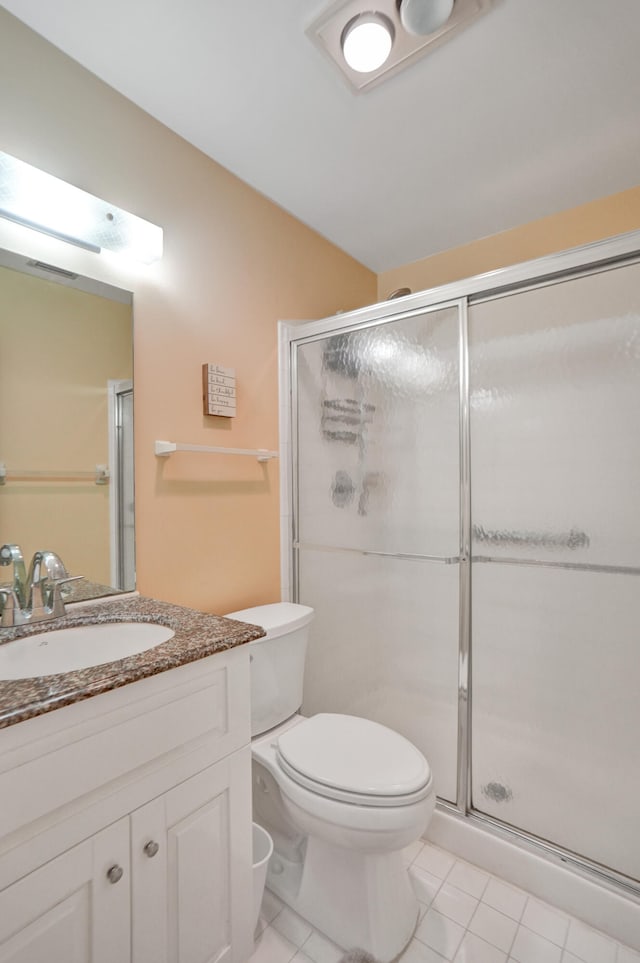 bathroom with tile patterned flooring, vanity, toilet, and a shower with shower door