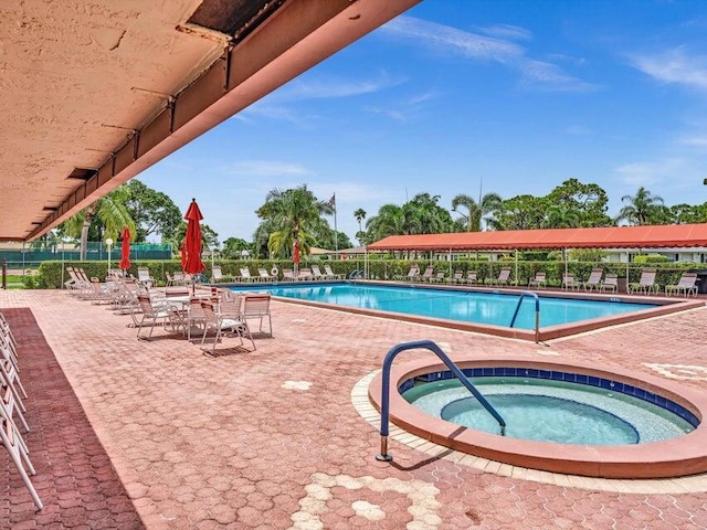 view of swimming pool featuring a community hot tub and a patio