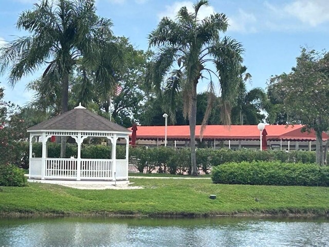 surrounding community with a gazebo, a lawn, and a water view