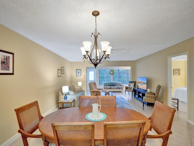 dining room featuring a textured ceiling, light tile patterned flooring, and ceiling fan with notable chandelier