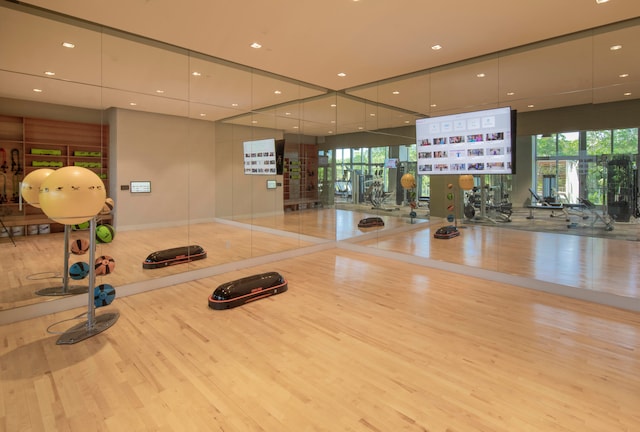 exercise room with light wood-type flooring