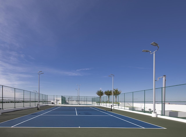 view of tennis court featuring a water view and basketball court