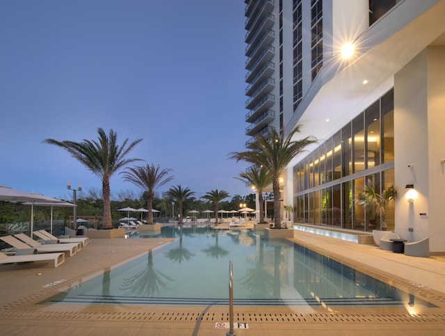 pool at dusk with a patio area