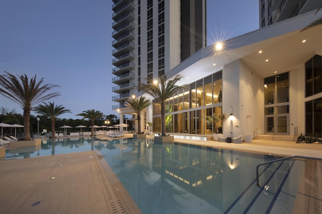 pool at dusk featuring a patio area