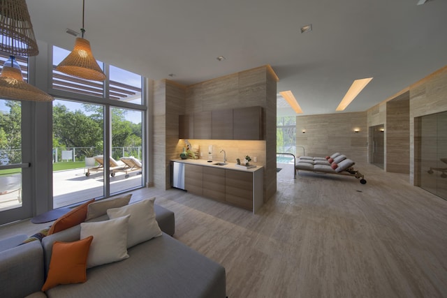 interior space featuring light wood-type flooring, a high ceiling, floor to ceiling windows, and access to exterior