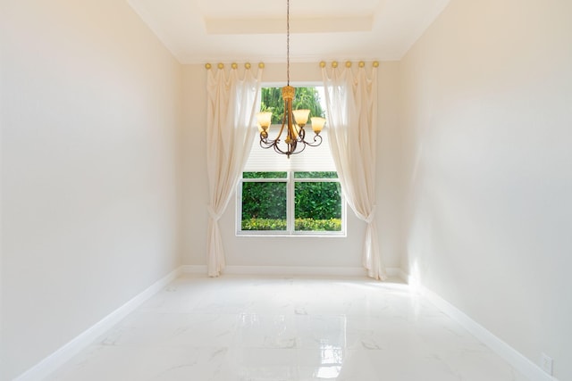 unfurnished room with a notable chandelier and a tray ceiling