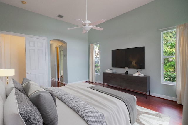 bedroom with dark wood-type flooring, ceiling fan, and multiple windows