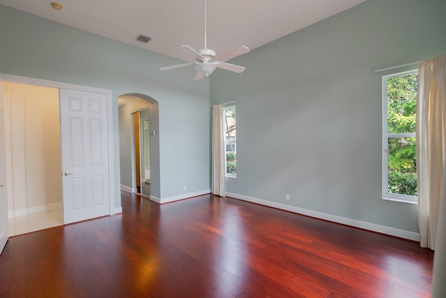 unfurnished bedroom featuring multiple windows and dark wood-type flooring