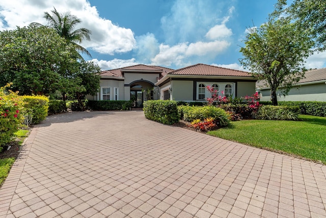 mediterranean / spanish-style home with a front lawn