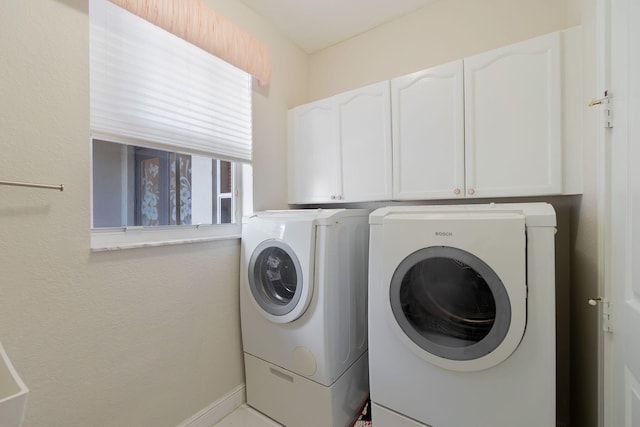 laundry area with washer and clothes dryer and cabinets