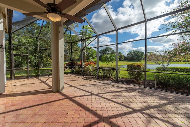 view of patio featuring a lanai, ceiling fan, and a water view