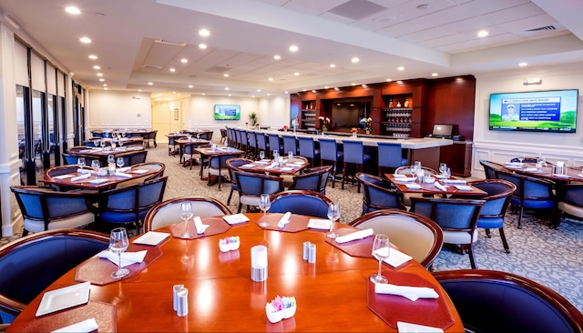 carpeted dining space with indoor bar