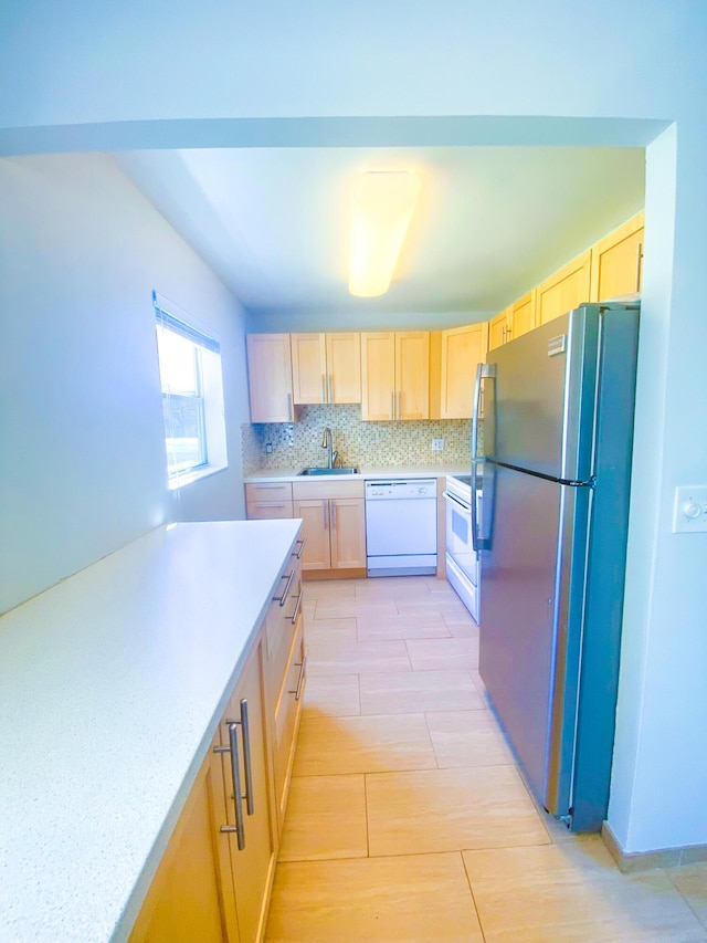 kitchen with light brown cabinets, white appliances, backsplash, and sink