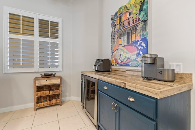 bar with blue cabinets, light tile patterned floors, and wine cooler