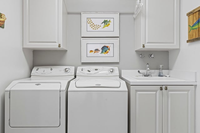 clothes washing area featuring cabinets, sink, and washing machine and clothes dryer