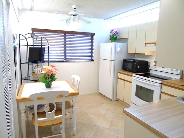 15451 Pembridge Dr Unit 217, Delray Beach, FL 33484 - kitchen featuring light tile patterned flooring, white appliances, ceiling fan, white cabinets, and under cabinet range hood
