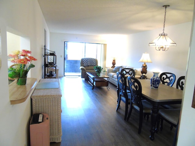 dining space with an inviting chandelier and dark wood finished floors