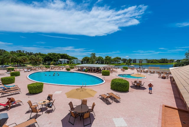 community pool featuring a water view and a patio area