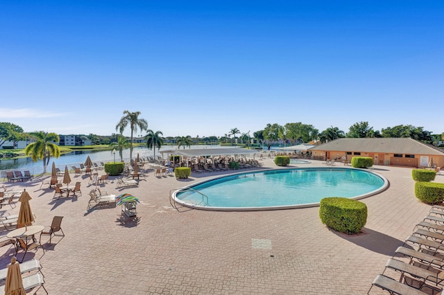 view of pool featuring a patio and a water view