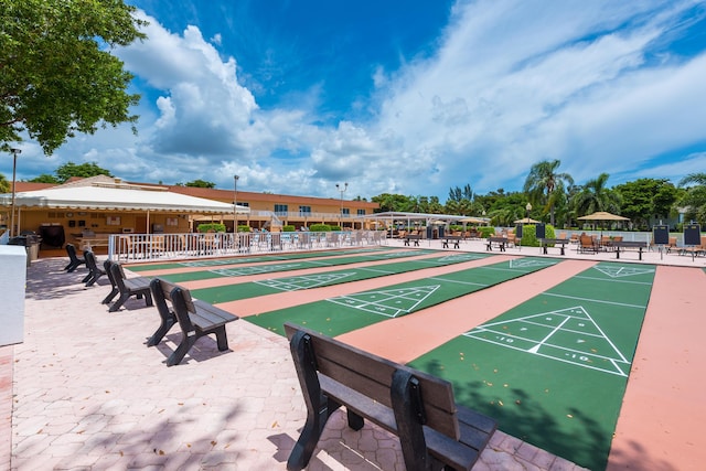 view of home's community featuring fence and shuffleboard