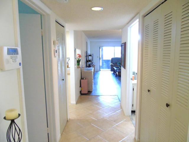 hallway with recessed lighting and light tile patterned flooring