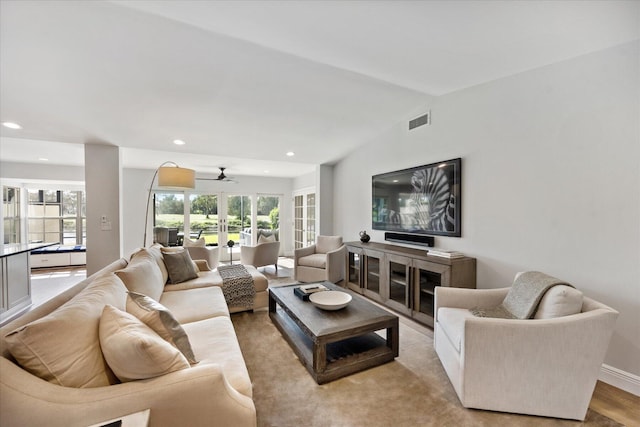 living room with lofted ceiling, ceiling fan, french doors, and light wood-type flooring