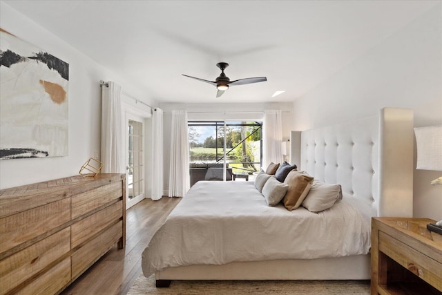 bedroom with hardwood / wood-style floors, ceiling fan, and access to exterior