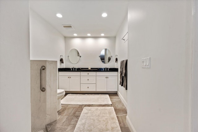 bathroom with oversized vanity, a tile shower, toilet, double sink, and tile floors