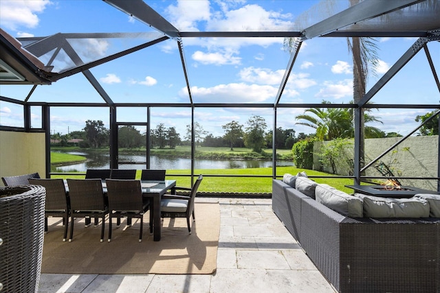 sunroom featuring a water view