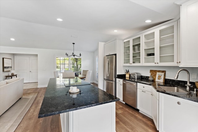 kitchen featuring a center island, wood-type flooring, white cabinetry, stainless steel appliances, and sink