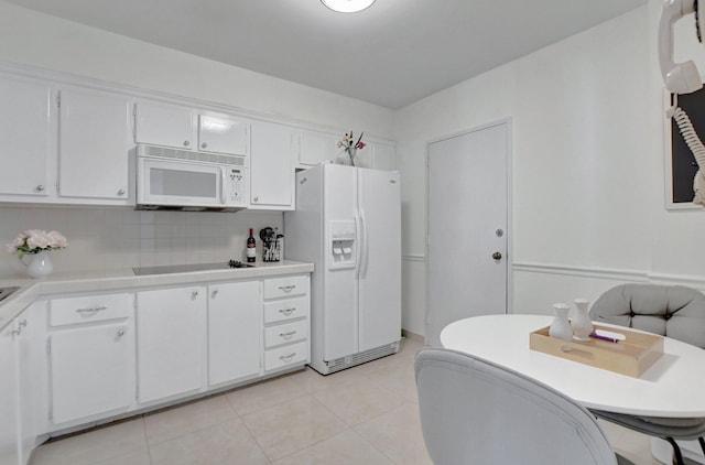 kitchen featuring light tile patterned floors, white cabinets, and white appliances