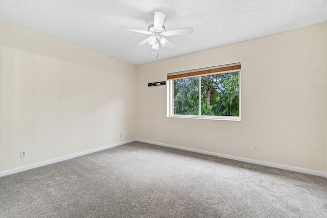 carpeted spare room featuring ceiling fan and a textured ceiling