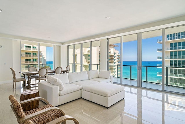 living room featuring light tile flooring, expansive windows, and a water view