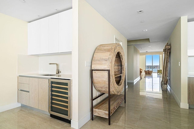 hallway featuring sink, wine cooler, and tile flooring