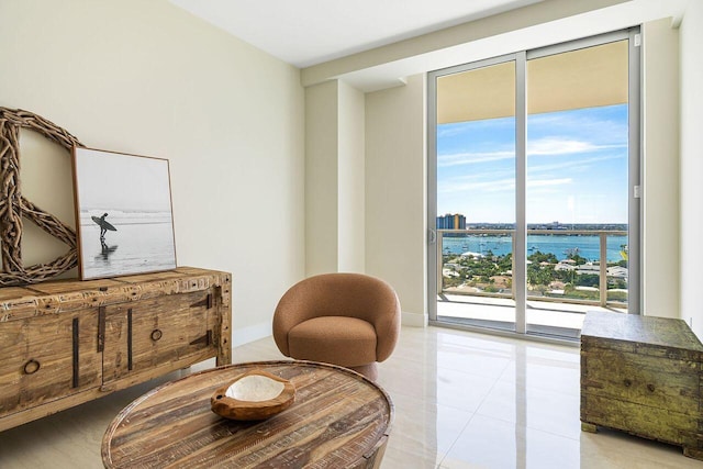 sitting room with a water view and light tile floors