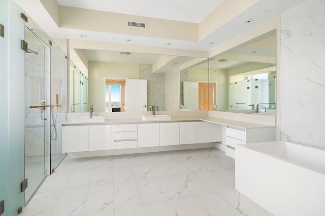 bathroom featuring a shower with door, dual bowl vanity, and tile floors