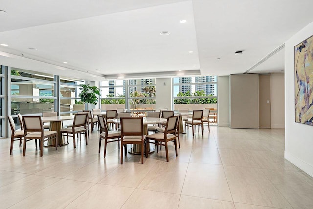 dining space with expansive windows and light tile floors