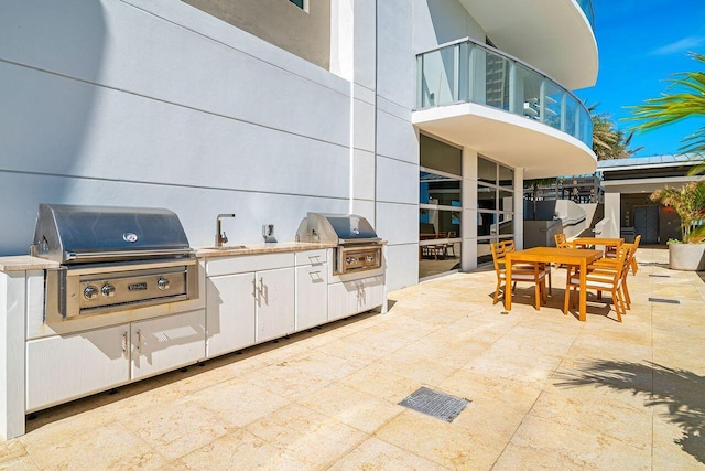 view of patio featuring a balcony, exterior kitchen, and grilling area