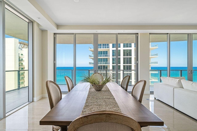 dining space with light tile flooring and a water view