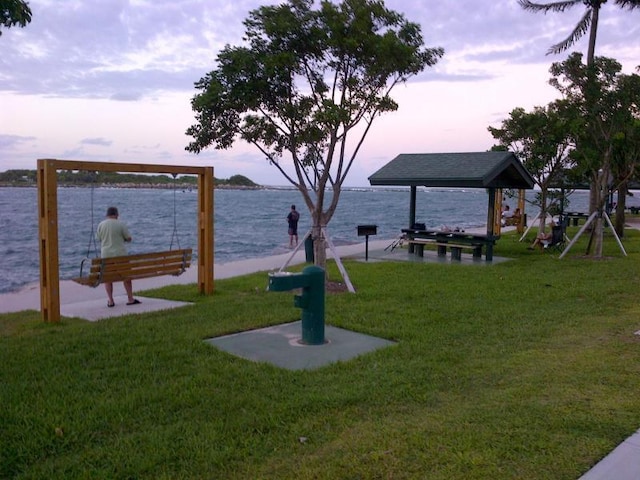 yard at dusk featuring a water view