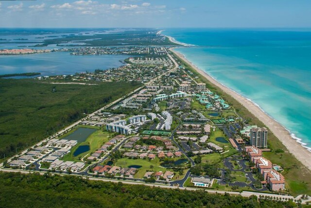 birds eye view of property with a water view and a beach view