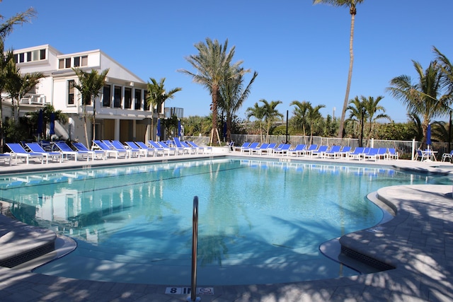 pool with a patio area and fence