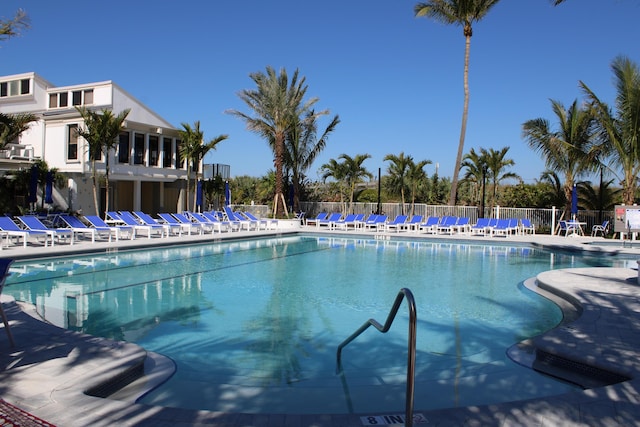 community pool with a patio and fence