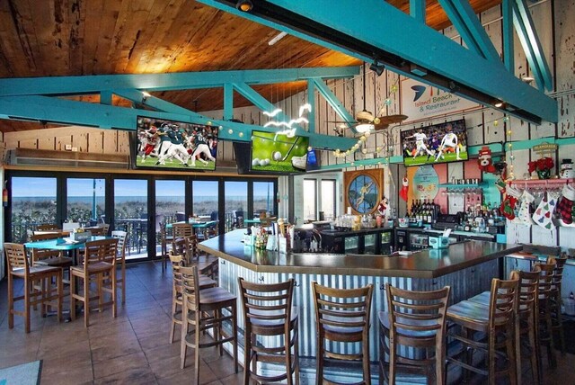 bar with wood ceiling, tile patterned flooring, a dry bar, and vaulted ceiling with beams