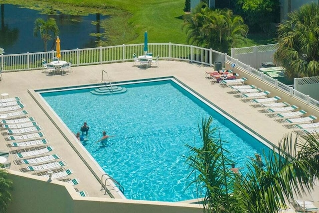 view of pool with a water view and a patio